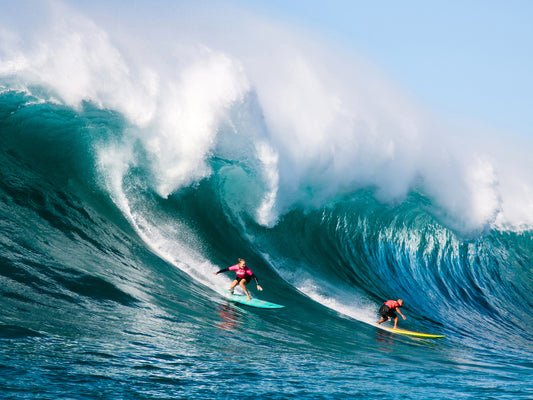 Paige Alms and Ramón Navarro tag-team one of the first-ever coed waves ridden in the Eddie Aikau Big Wave Invitational. Photo: Christa Funk